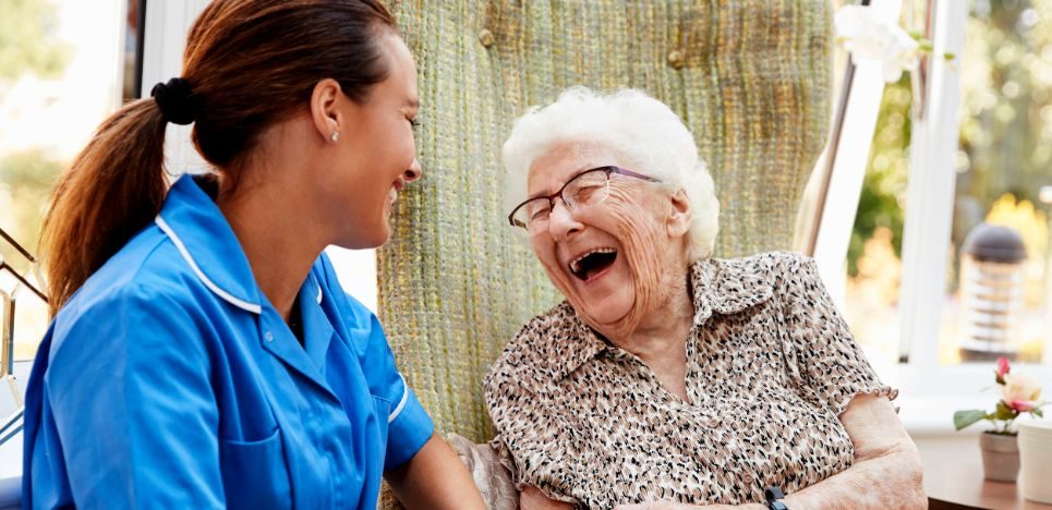 Older adult and care partner laughing