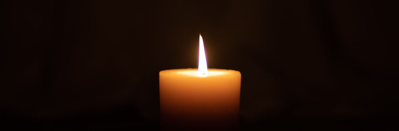 Single candle on dark background