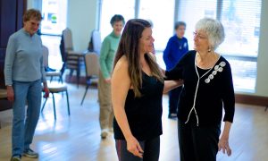 Dance instructor talking with resident during class