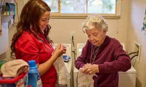 Home care client and care partner folding laundry
