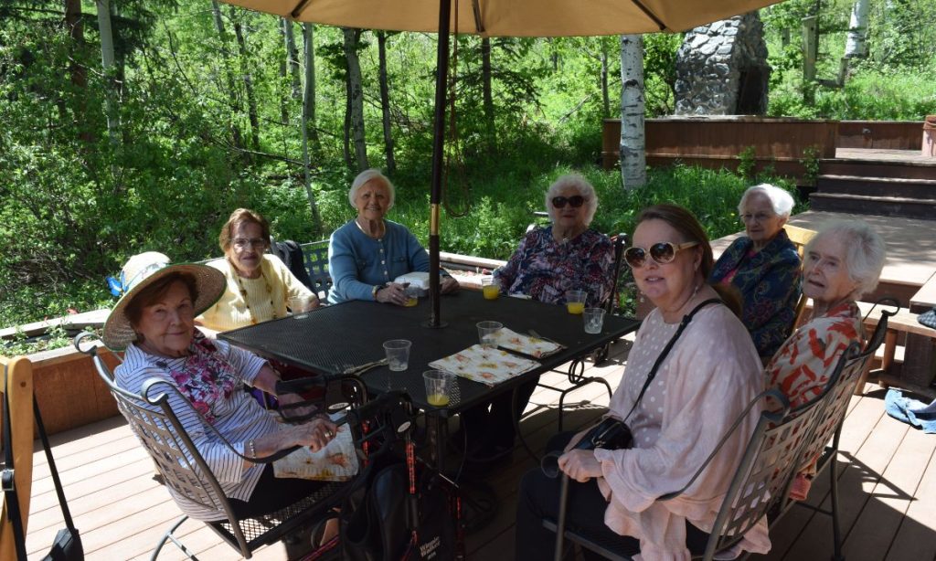 Residents sitting together on a Rocky Mountain patio